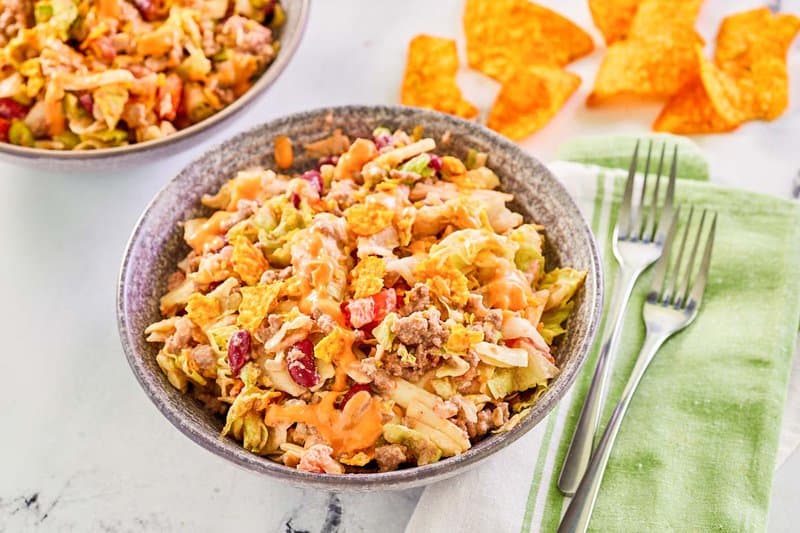 Dorito taco salad, forks, and Doritos tortilla chips.