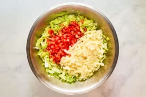 Chopped lettuce, tomato, and cheese in a large bowl.
