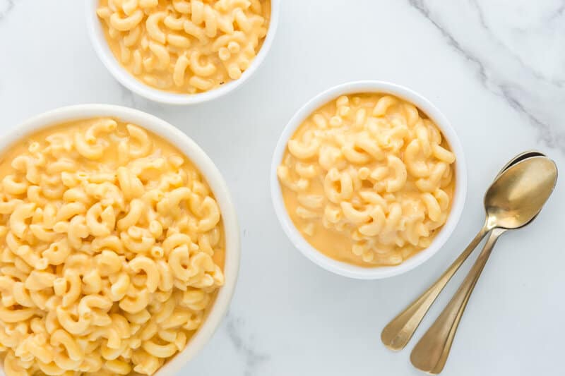 Overhead view of copycat KFC mac and cheese in three bowls and three spoons.