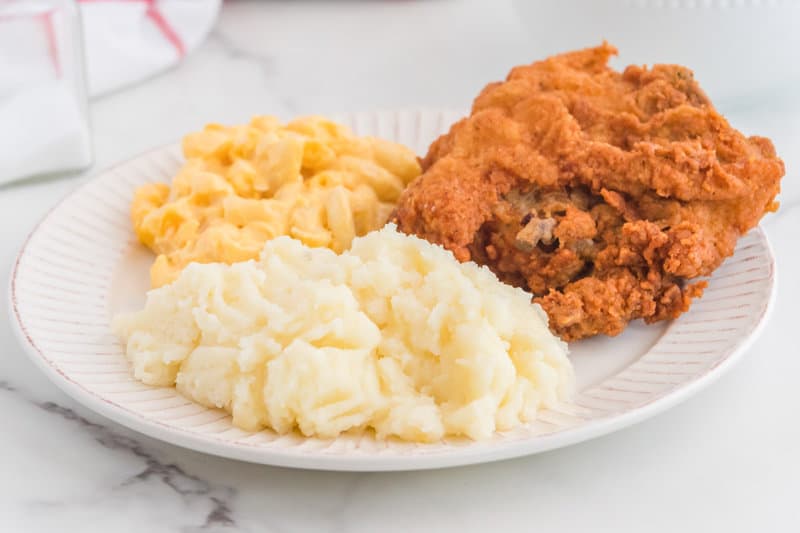 Copycat KFC mashed potatoes, mac and cheese, and fried chicken on a plate.