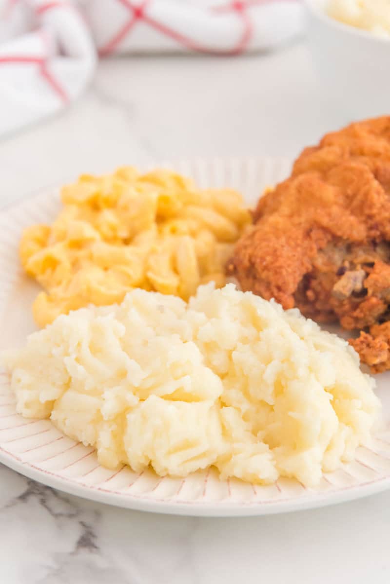 Copycat KFC-Kartoffelpüree, Brathähnchen und Makkaroni mit Käse auf einem Teller.