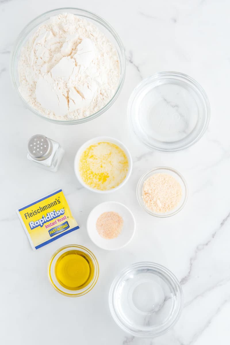 Copycat Little Caesars crazy bread ingredients on a marble surface.