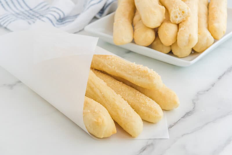 Copycat Little Caesars crazy bread on a plate and wrapped in parchment paper.