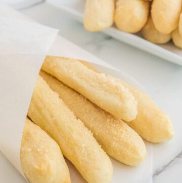 Copycat Little Caesars crazy bread wrapped in parchment and on a platter.