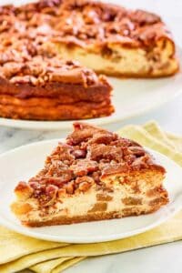 Copycat Olive Garden apple praline cheesecake on a plate and the cheesecake behind it.