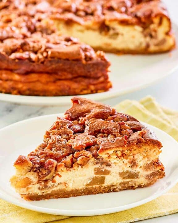 Copycat Olive Garden apple praline cheesecake on a plate and the cheesecake behind it.
