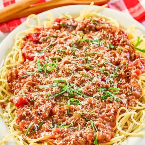 Homemade meat sauce over spaghetti on a platter.