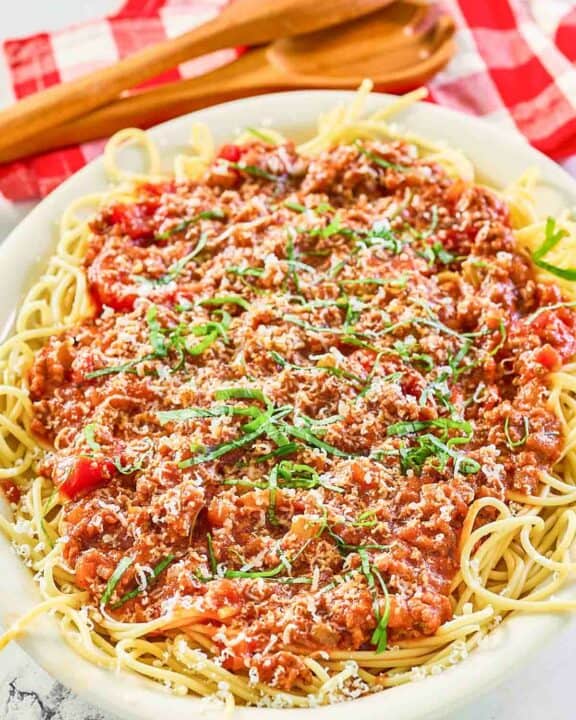 Homemade meat sauce over spaghetti on a platter.
