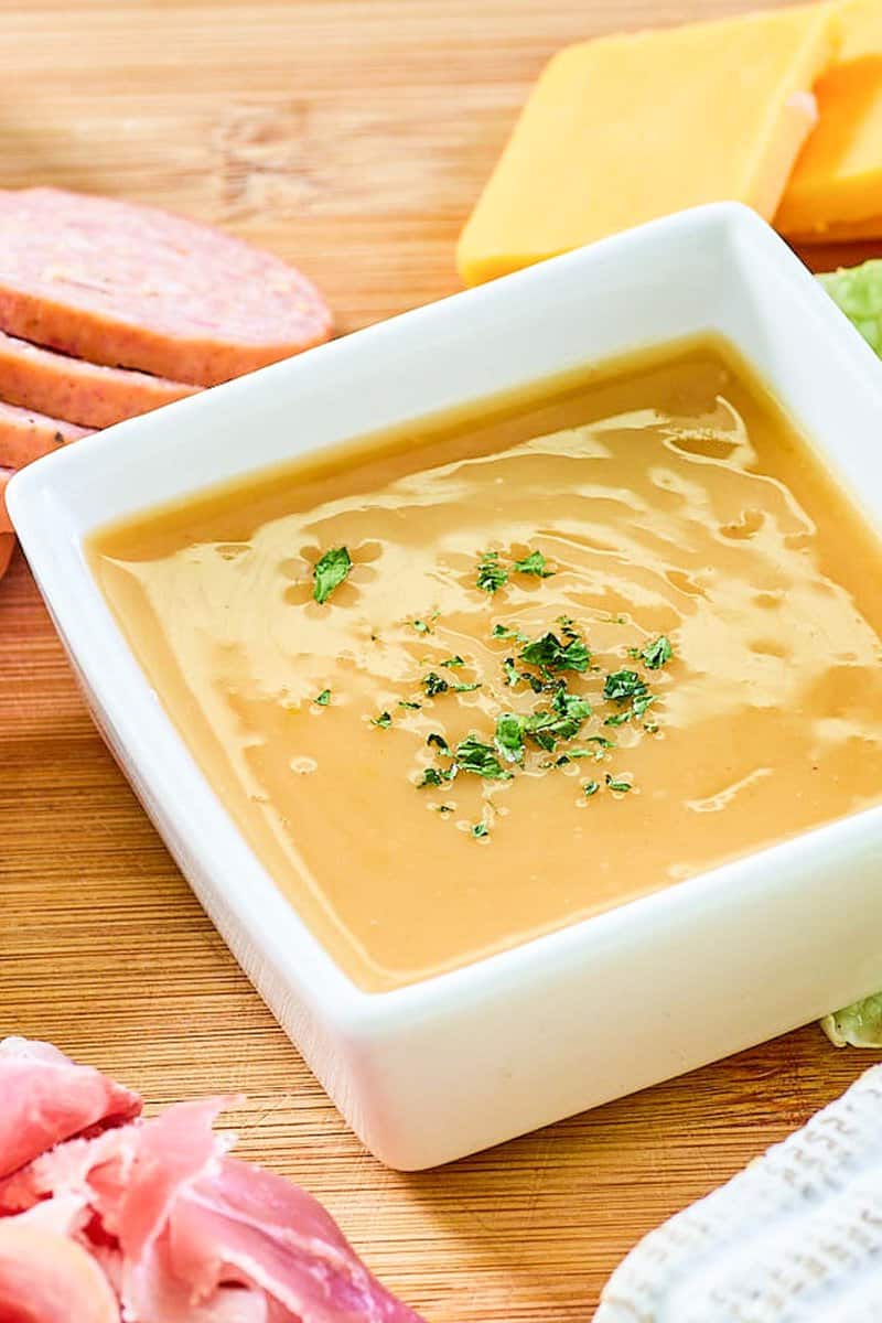 Closeup of homemade sweet hot mustard in a small square bowl.