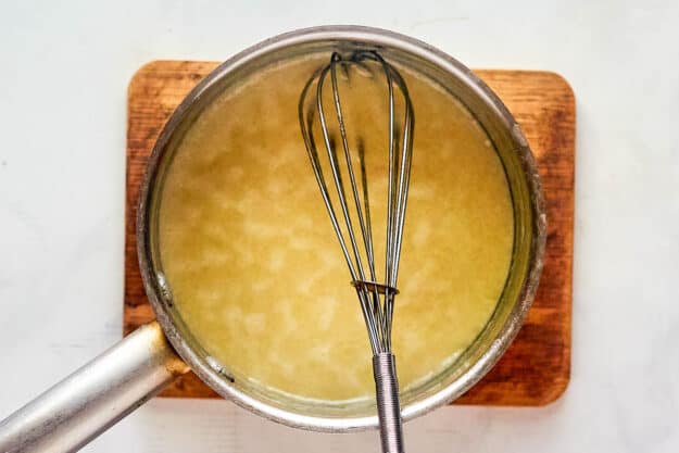 Chicken broth, butter, and flour mixture in a saucepan.