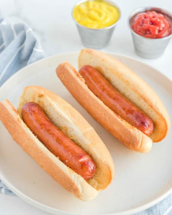 Two air fryer hot dogs on a plate.