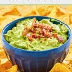 A bowl of sour cream avocado dip and tortilla chips around it.