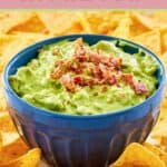 A bowl of creamy avocado dip topped with bacon bits.