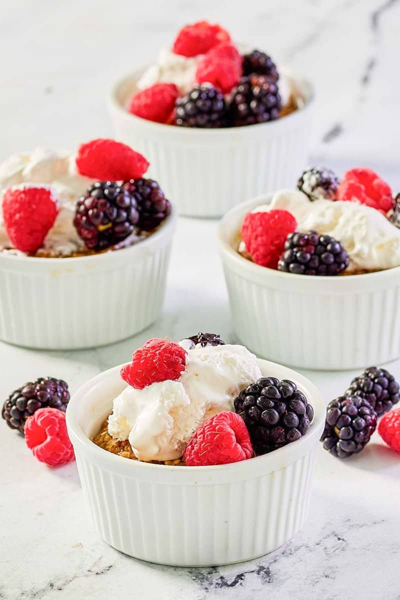 Copycat Brennan's oatmeal custard with whipped cream and berries in ramekins.