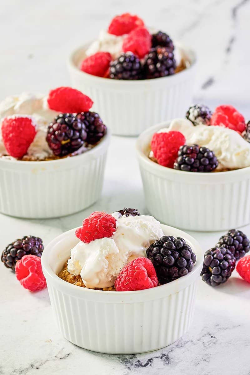 Copycat Brennan's oatmeal custard with whipped pick  and berries successful  ramekins.