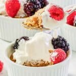 Copycat Brennan's oatmeal custard with whipped cream and berries on a spoon and in ramekins.