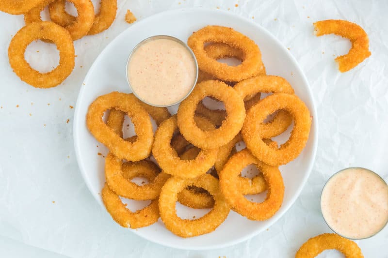 Overhead view of copycat Burger King zesty sauce and onion rings.