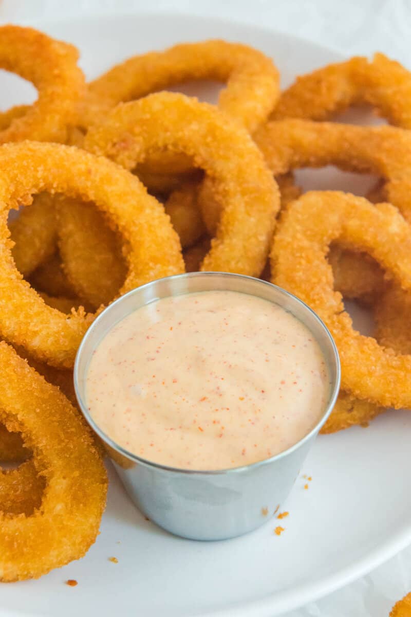 Copycat Burger King zesty sauce and onion rings on a plate.