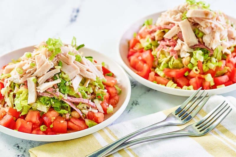 Two bowls of copycat California Pizza Kitchen Italian chopped salad.