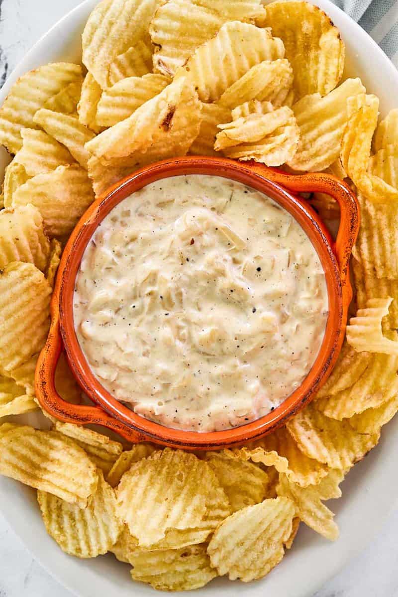 Overhead view of Ina Garten onion dip and potato chips on a platter.
