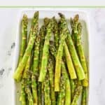 Oven roasted asparagus spears on a white platter.