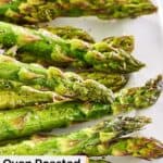 Closeup of roasted asparagus on a white plate.