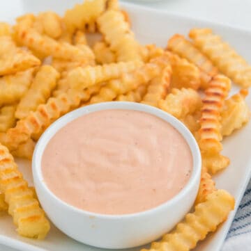 Copycat Raising Cane's sauce and crinkle-cut French fries on a plate.