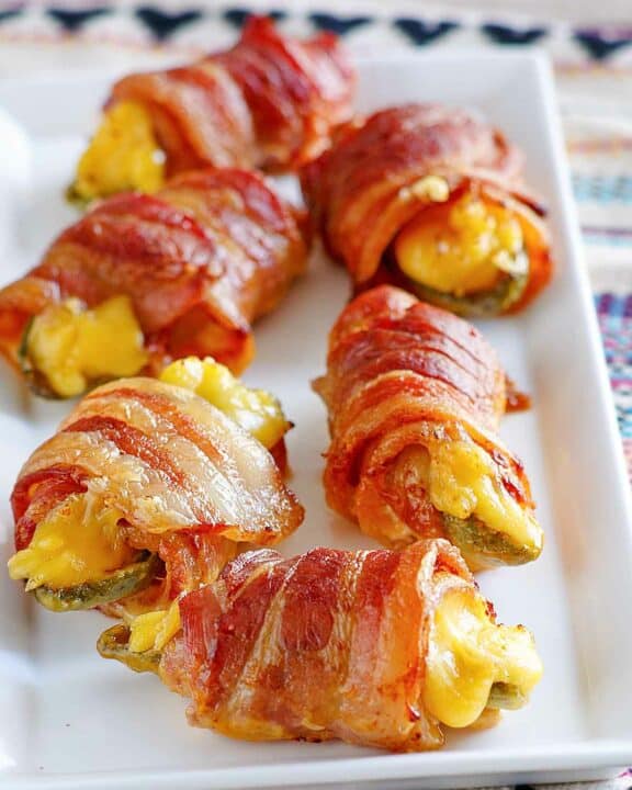 Air fryer bacon wrapped jalapeno poppers on a platter.