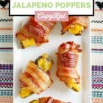 Overhead view of air fryer bacon wrapped cheese stuffed jalapeno peppers on a platter.