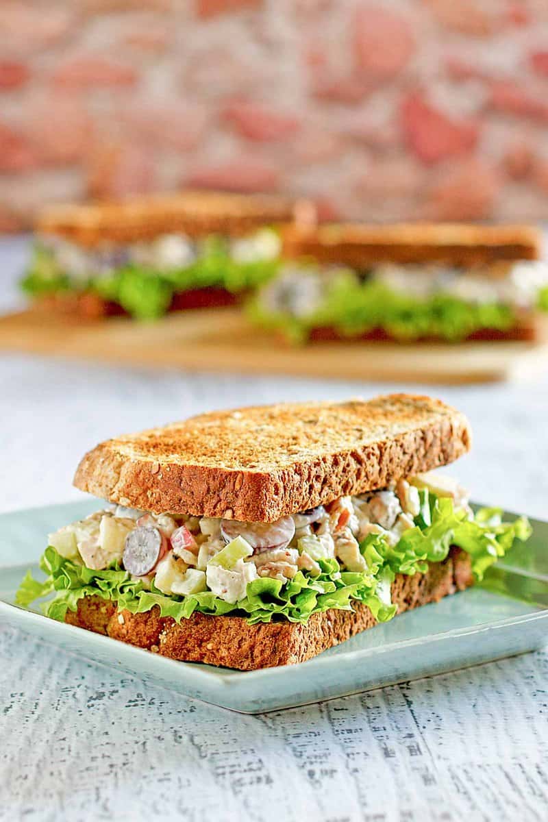Copycat Arby's pecan chicken salad sandwich on a square plate.