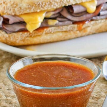 Copycat Arby's sauce in front of a roast beef sandwich.