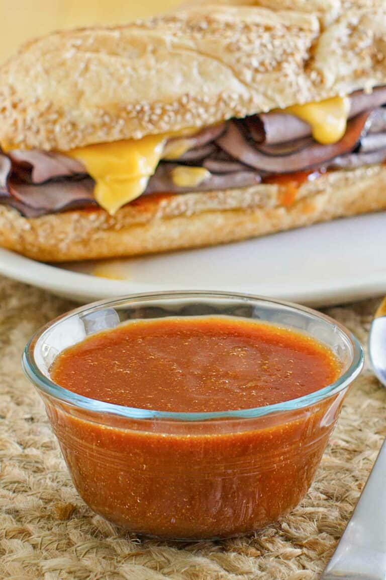 Copycat Arby's sauce in front of a roast beef sandwich.