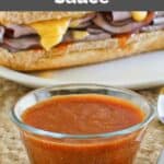 Homemade Arby's sauce in front of a roast beef sandwich.
