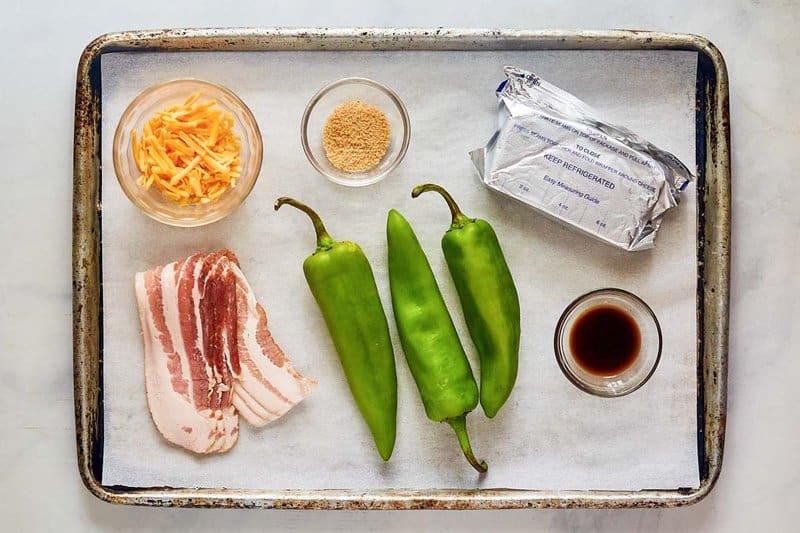 Bacon wrapped stuffed hatch peppers ingredients on a tray.