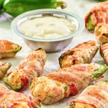 Bacon wrapped buffalo chicken jalapeno poppers, dipping sauce, and jalapeno peppers.