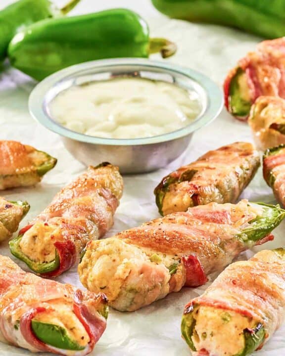 Bacon wrapped buffalo chicken jalapeno poppers, dipping sauce, and jalapeno peppers.