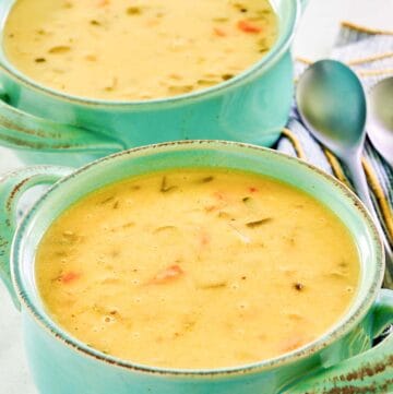 Homemade cheddar cheese soup in two soup crocks.