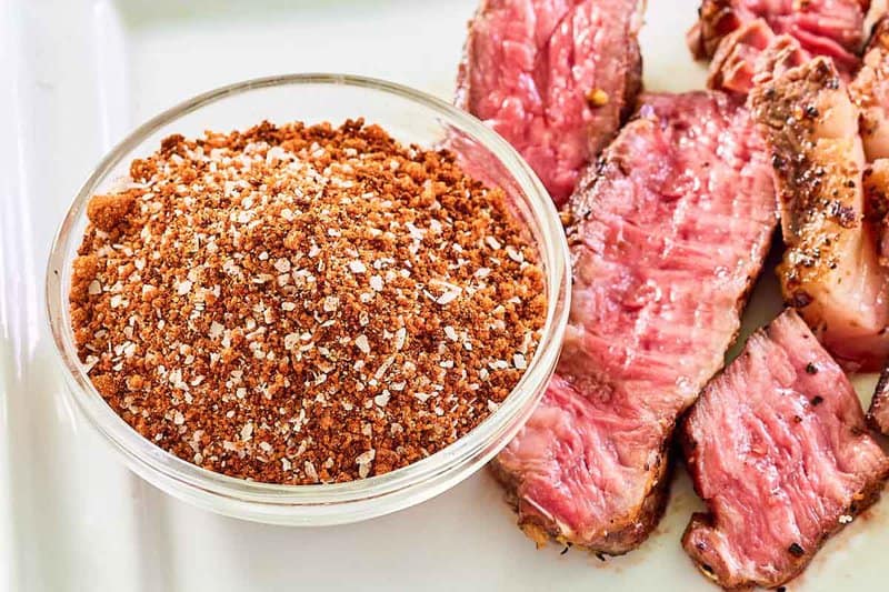 Homemade coffee rub in a bowl and steak next to it.