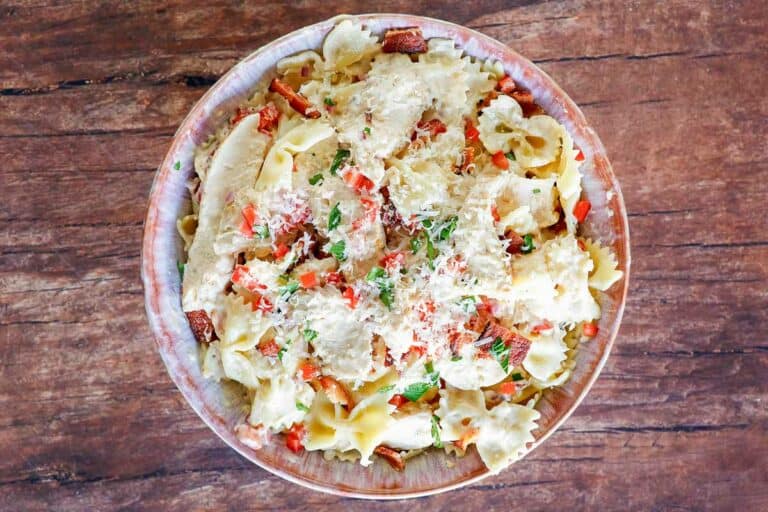 Bowtie pasta in creamy sauce with chicken, bacon, and vegetables.