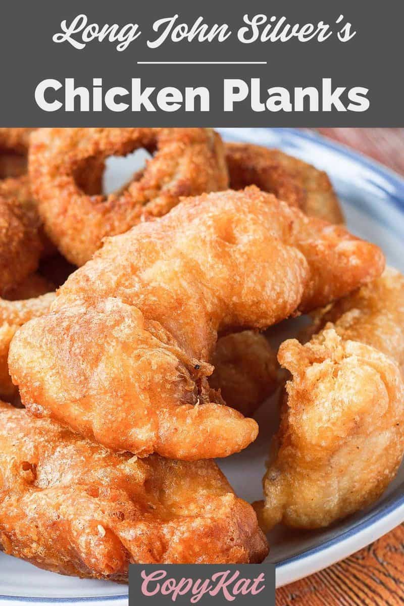 Several homemade Long John Silver's chicken planks and onion rings on a plate.