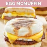 Homemade McDonald's sausage egg mcmuffin and one cut in half behind it.