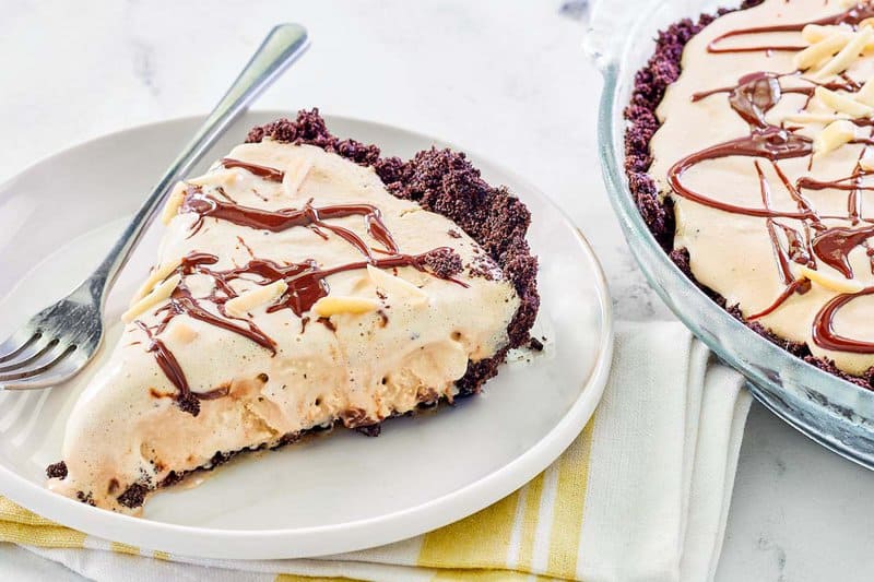 A slice of ice cream mud pie and a fork on a plate.