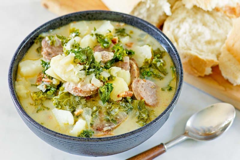 Copycat Olive Garden Zuppa Toscana soup, a spoon, and bread.