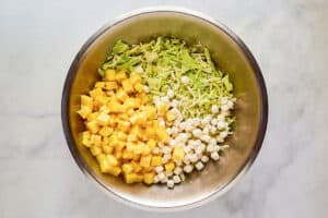 Pineapple coleslaw ingredients in a large mixing bowl.