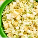 Closeup overhead view of pineapple coleslaw in a green bowl.
