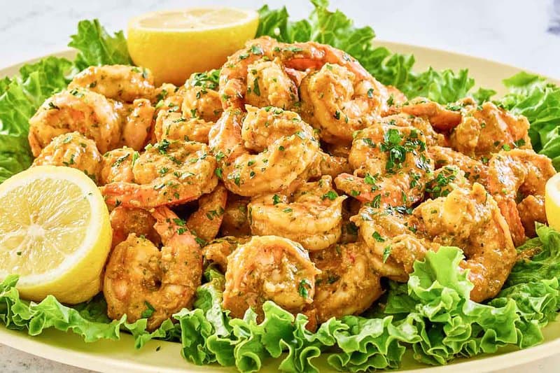 Shrimp remoulade, lettuce, and lemons on a platter.