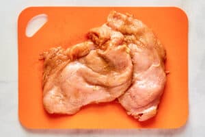 Seasoned raw chicken breasts.