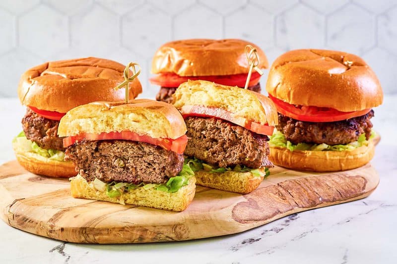 Four copycat 21 Club burgers and one cut in half.