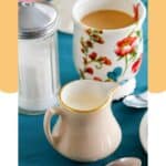 Homemade amaretto coffee creamer in a small pitcher and a cup of coffee.