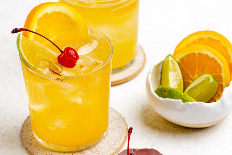 Copycat Applebee's white peach sangria and a bowl of lime and orange slices.